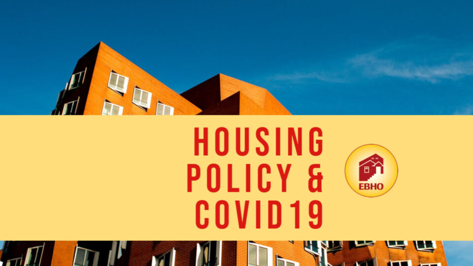image of a blue sky and a red brick apartment building with a yellow banner through the center of the picture that reads Housing Policy & Covid19